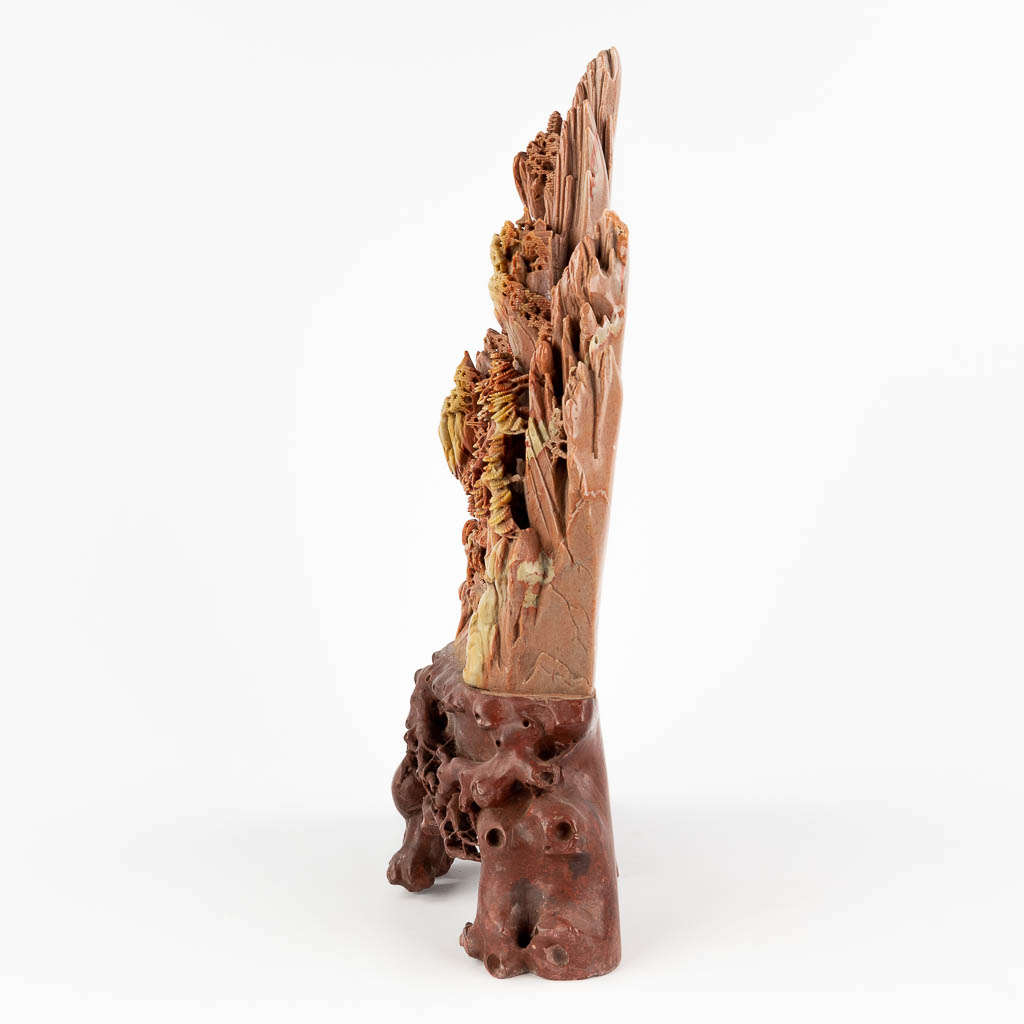 A large sculptured hardstone mountain landscape in a red hardstone. (L: 12 x W: 41 x H: 53 cm)