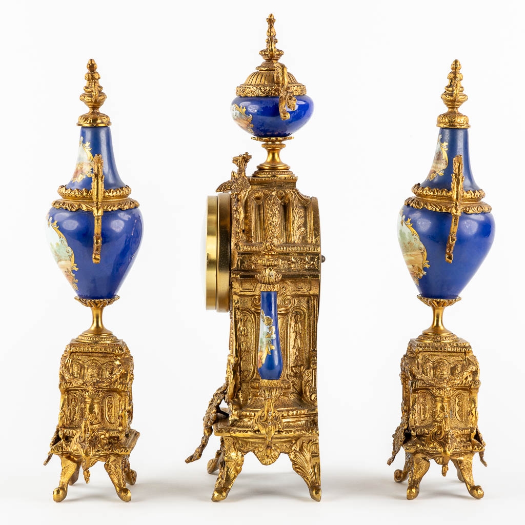 A three-piece mantle garniture clock and side pieces, bronze mounted with porcelain. (L:12 x W:20 x H:41 cm)
