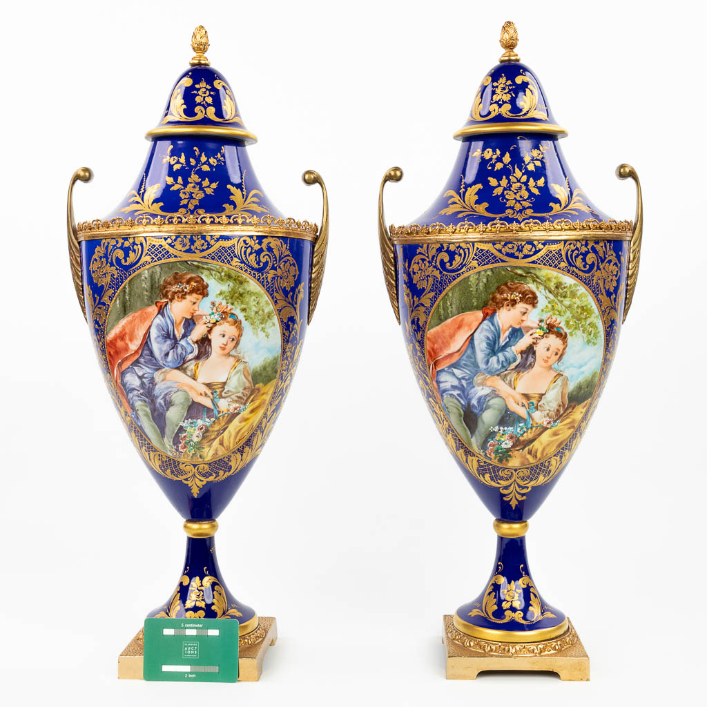 Een paar vazen gemaakt uit porselein met handgeschilderd decor in Sèvres stijl. Gemerkt s. Mannoli. (H:58cm)