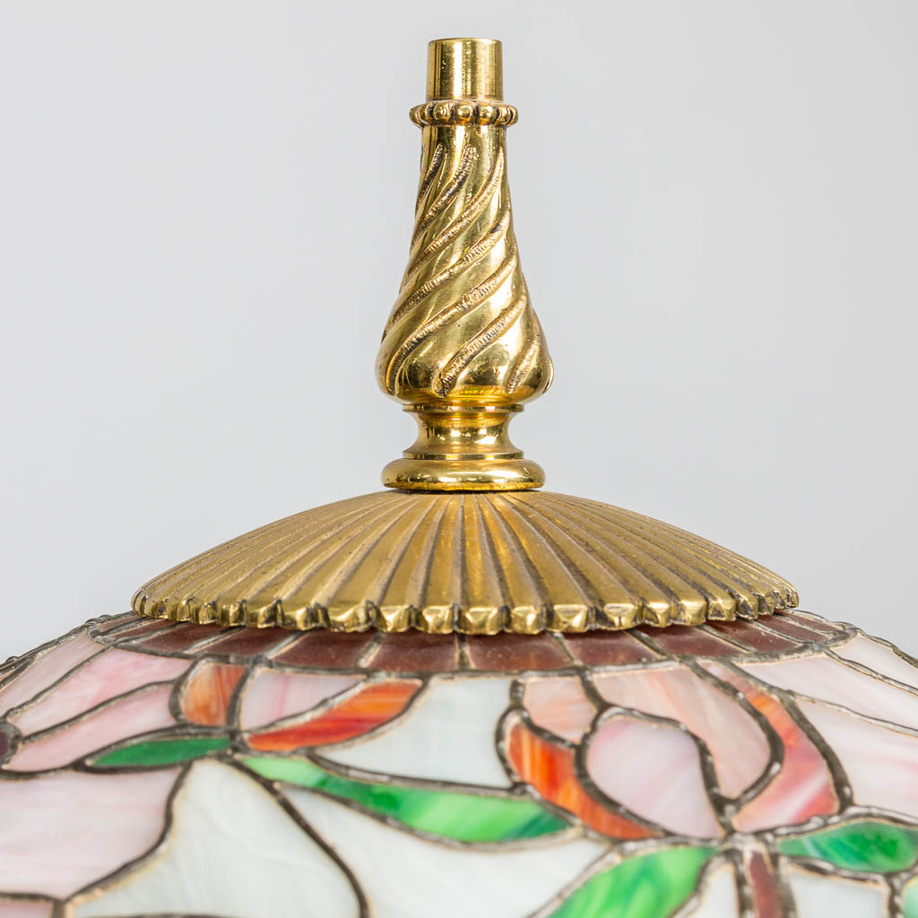 Een grote staande lamp gemaakt uit koper met een lampenkap in Tiffany Stijl. 