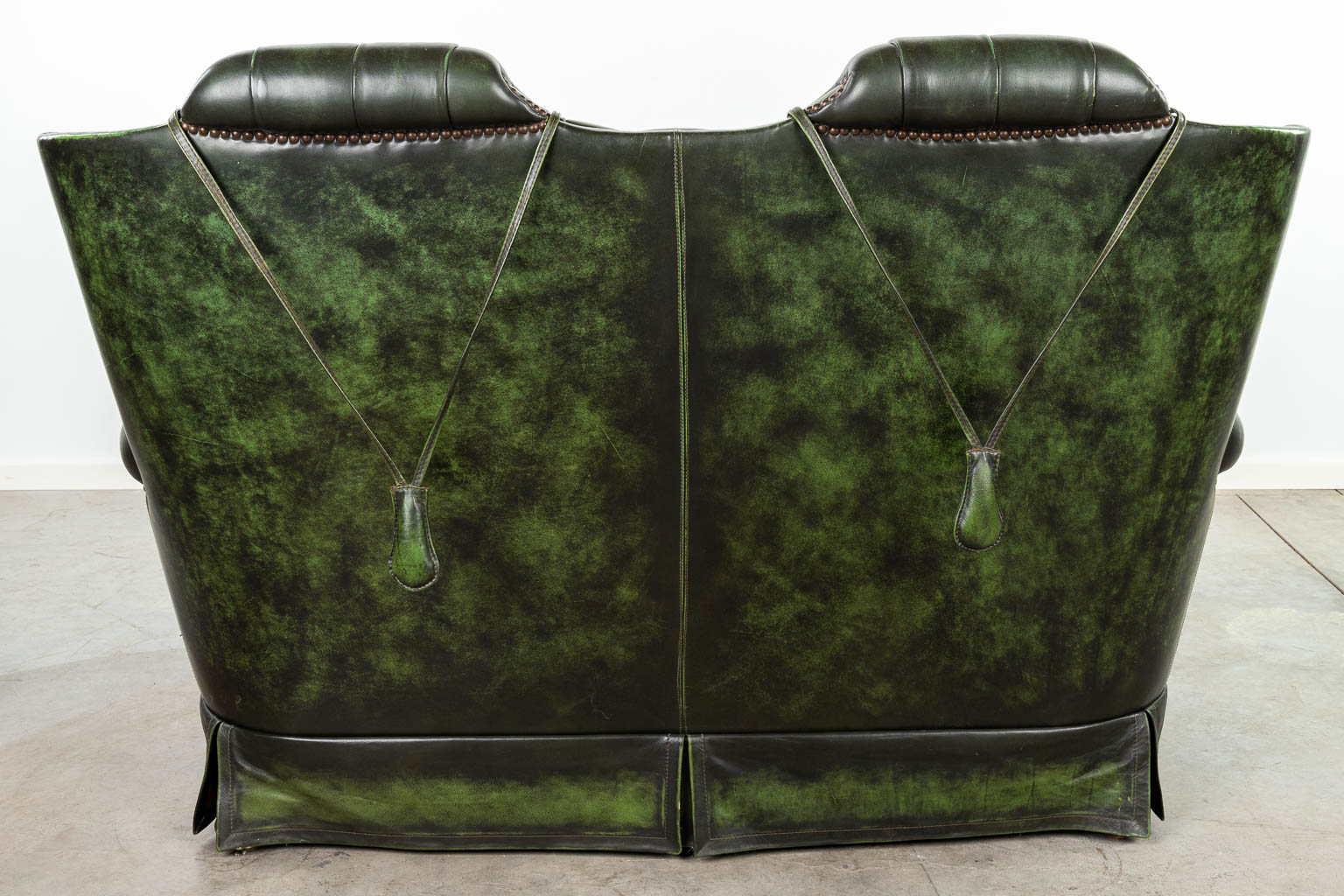 A green leather armchair with high back made in Chesterfield style. (H:107cm)