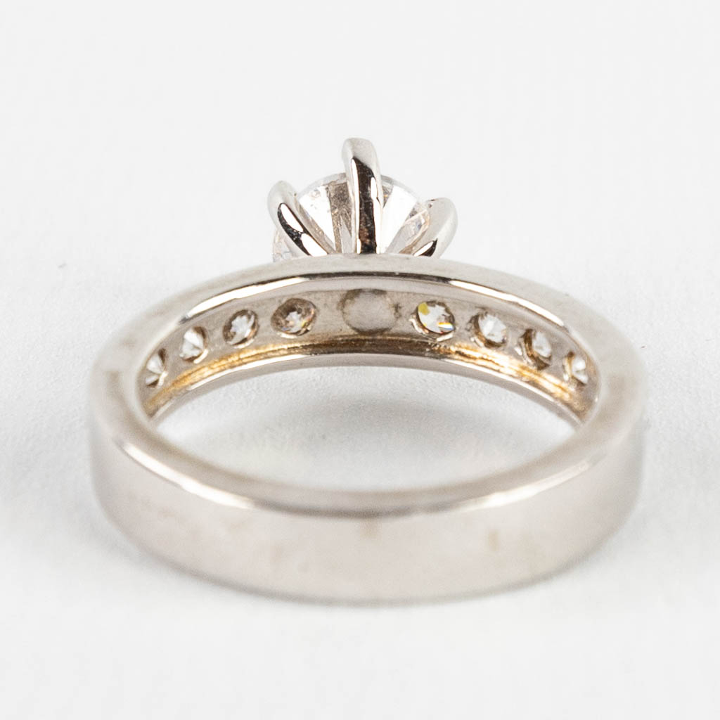 A ring with large solitaire and smaller stones/synthetic stones. Silver, marked 925.