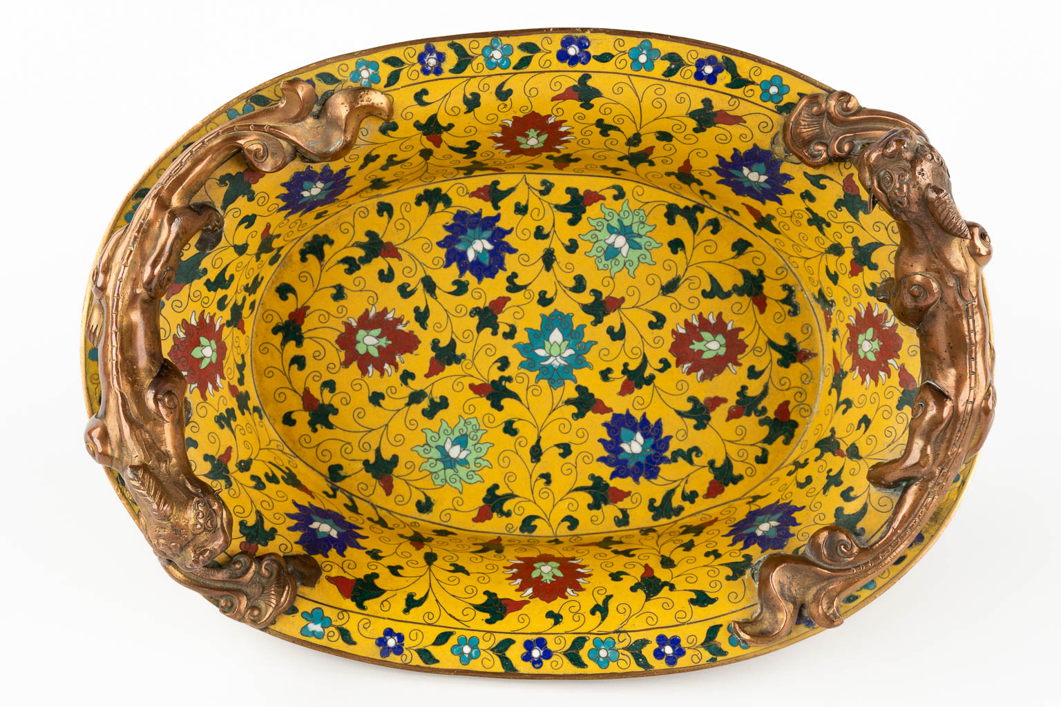 A Chinese cloisonné bronze bowl, mounted with dragons and finished with floral decor. (D:25,5 x W:36 x H:16 cm)