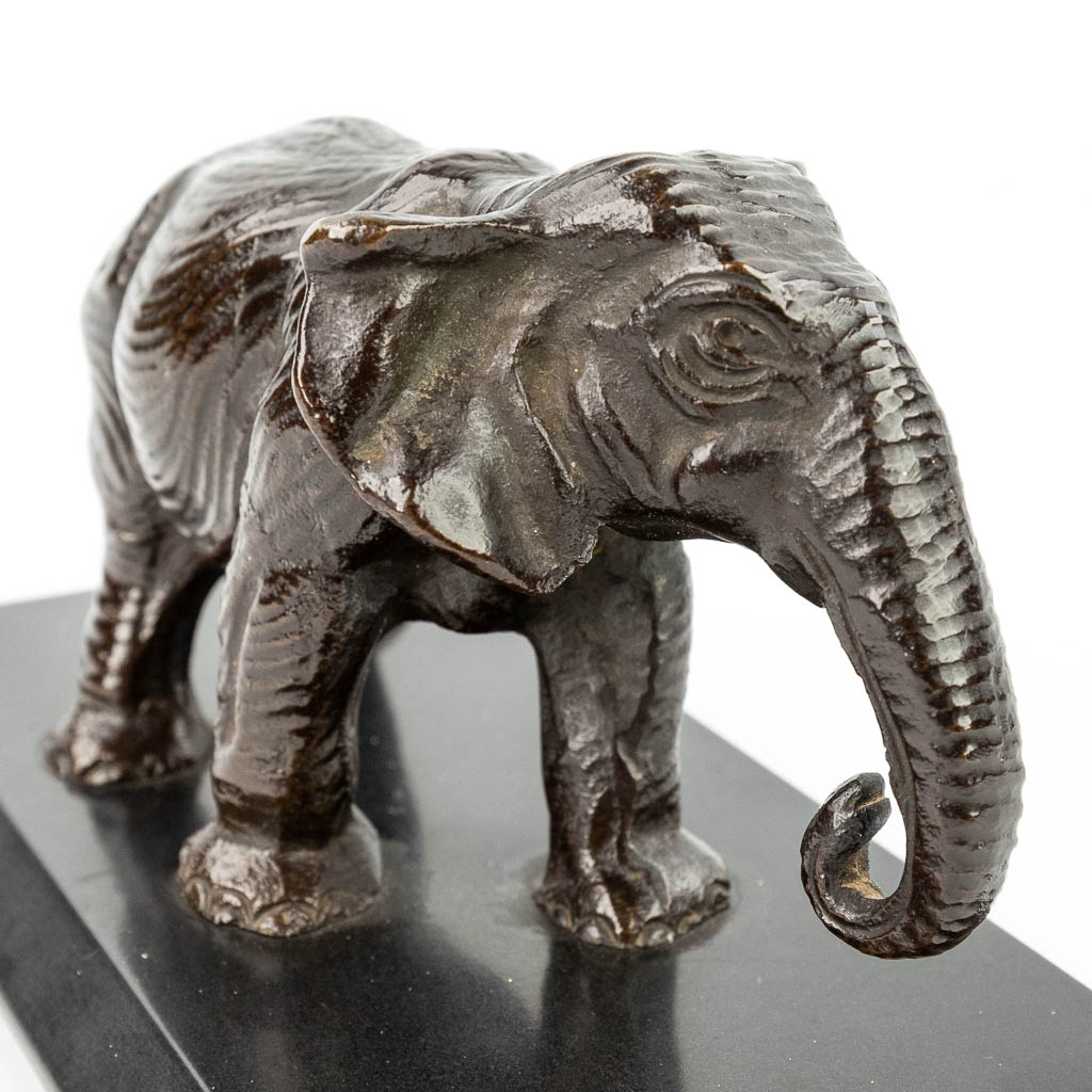 A statue of an elephant, made of patinated bronze and mounted on a black marble stand. (H:8cm)