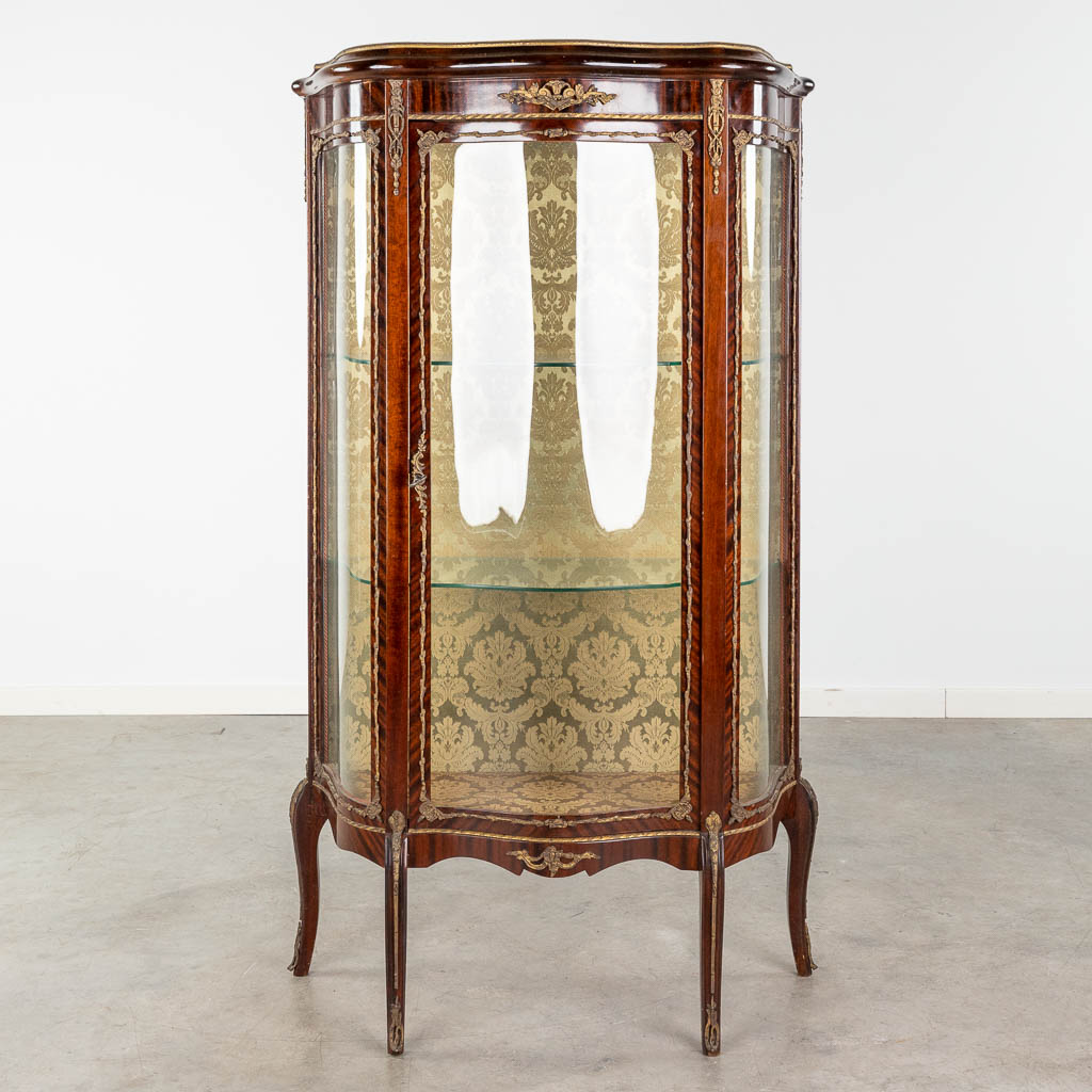 Een vintage vitrinekast afgewerkt met gebogen glas en brons in Lodewijk XV stijl. (L:35 x W:80 x H:140 cm)