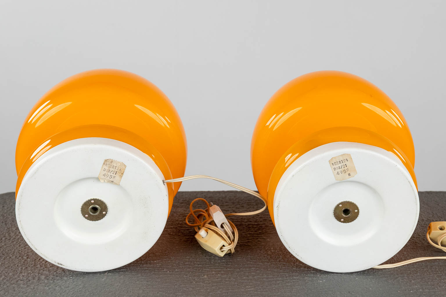 Two mid-century nightlamps and a ceiling lamp, orange glass on metal, circa 1970. (H:65 x D:30 cm)
