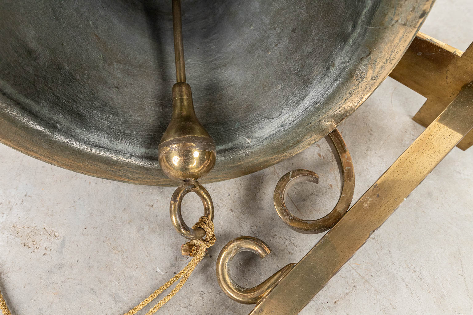 Een bronzen klok gemonteerd op een hangbeugel. (H:30cm)