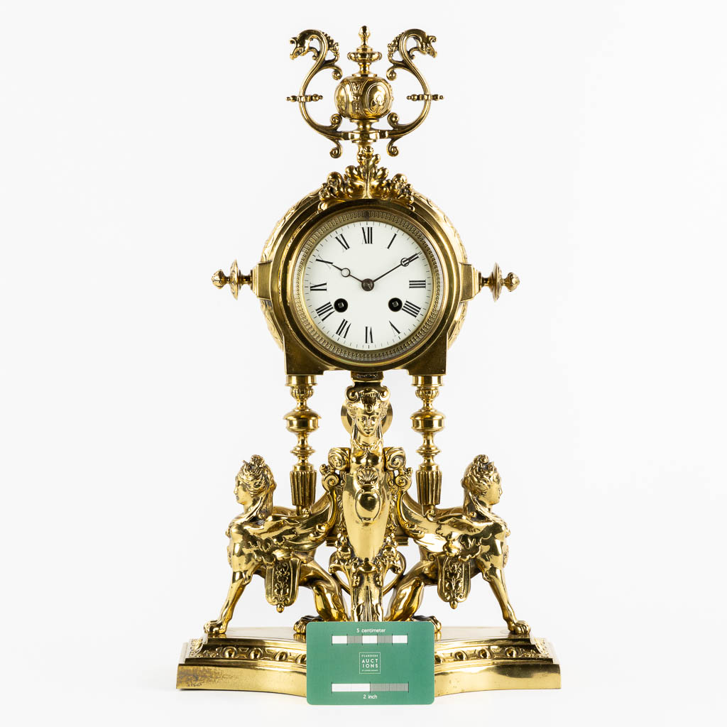 A mantle clock, polished bronze, decorated with Mythological Figures. Circa 1880. (L:15 x W:26 x H:45 cm)