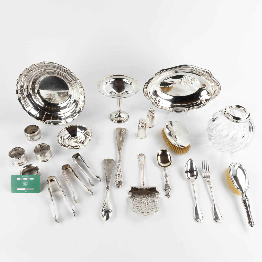 Een collectie tafelaccesoires en gebruiksgoederen, zilver. (D:20,5 x W:30 x H:4 cm)