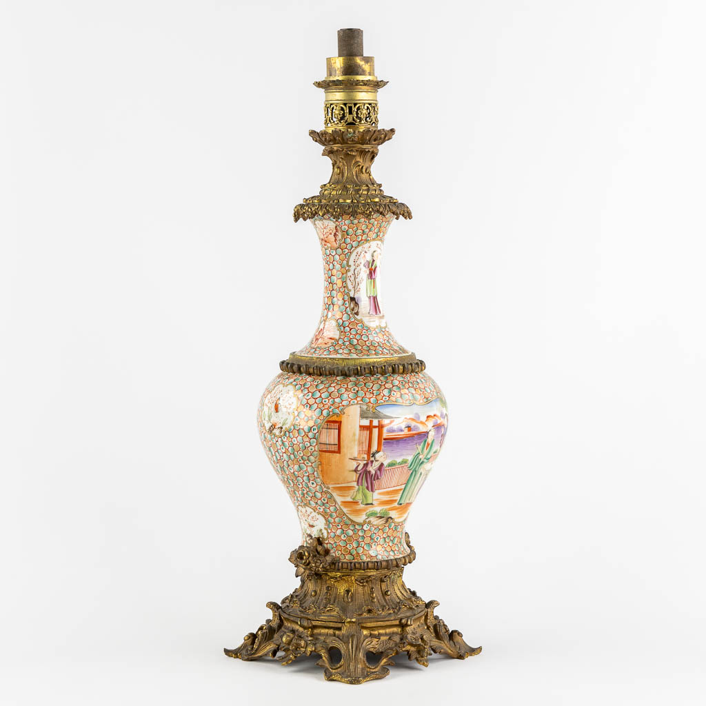 An antique oil lamp, Chinese Famille Rose porcelain mounted with gilt bronze. 19th C. (L:20 x W:20 x H:66 cm)