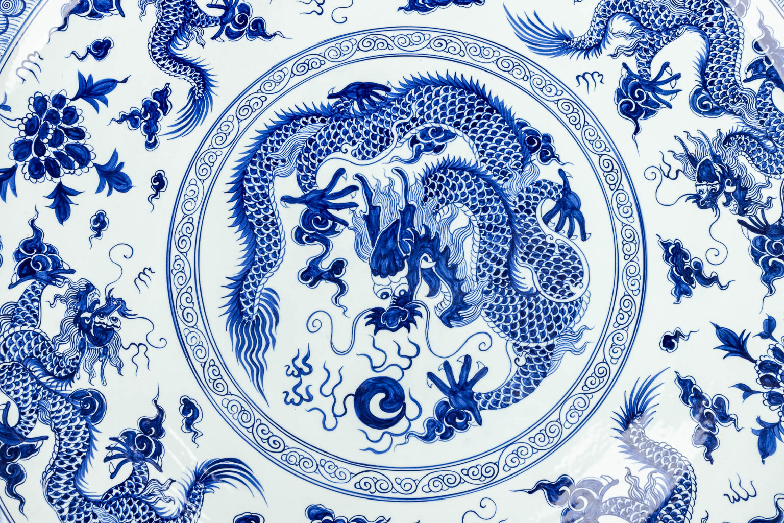 Een groot Chinees sierbord versierd met blauw-wit decor van draken. 20ste eeuw. 