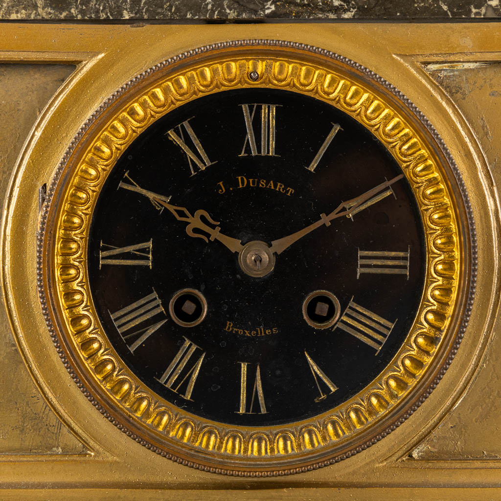 J. Dusart Bruxelles, A mantle clock. Gilt spelter and marble. Circa 1900. (L:20 x W:47 x H:46 cm)