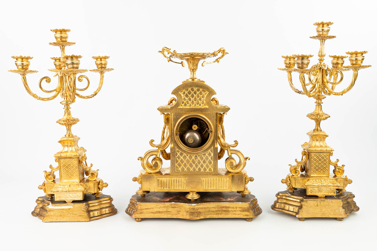 A three-piece garniture clock, inlaid with red marble and standing on wood bases. (H:38cm)