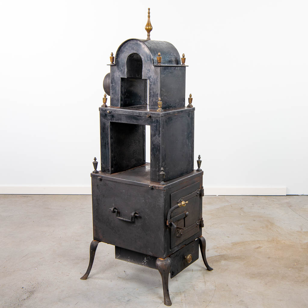 an antique wood-fired stove, decorated with bronze elements.