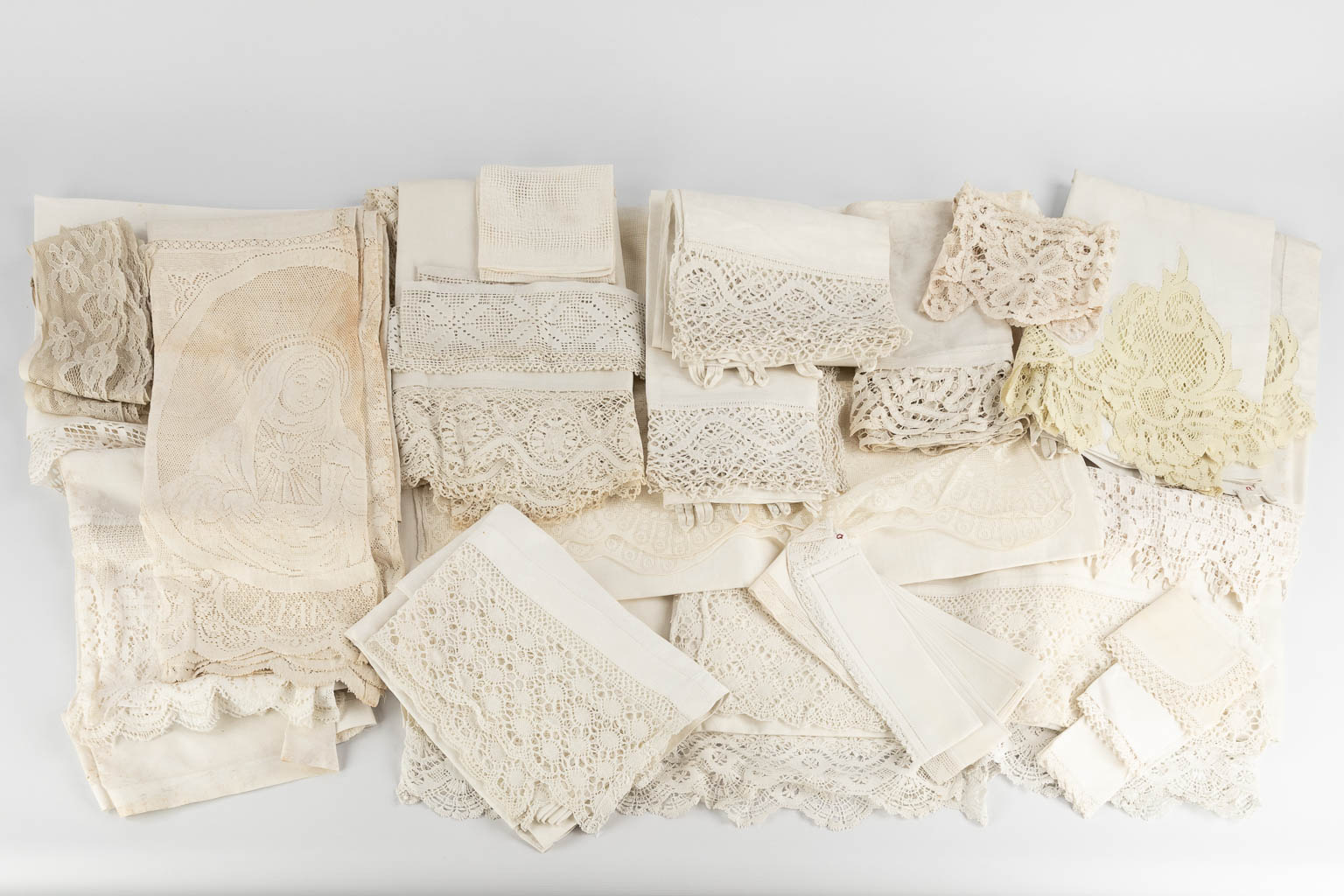 A large collection of textile and lace with Religious patterns and images. (W:380 x H:90 cm)