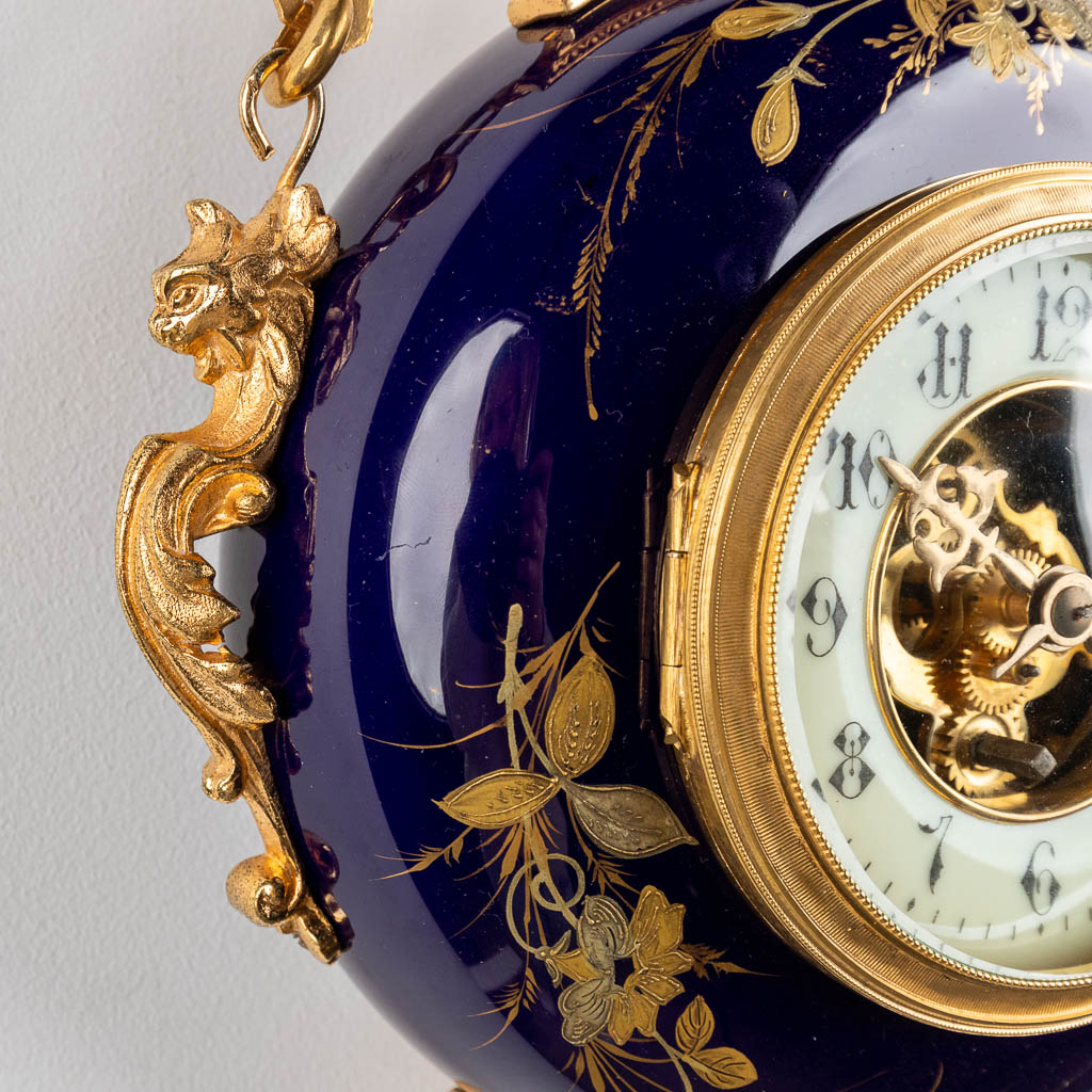 A hanging wall clock, cobalt blue porcelain mounted with bronze. 19th C. (W:26 x H:36 cm)