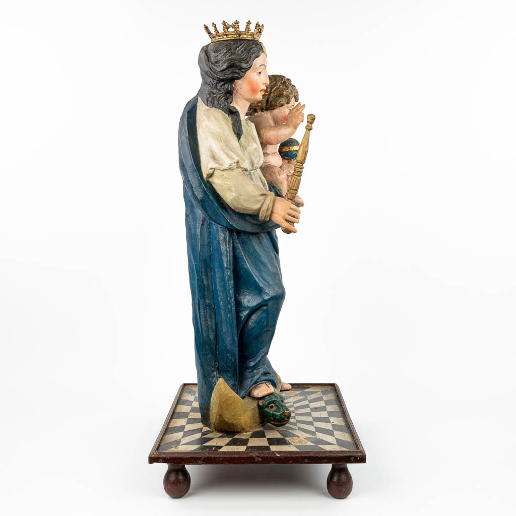 Een gepatineerd houten beeld van Madonna met kind, bovenop het serpent en een maansikkel (H: 90 cm)