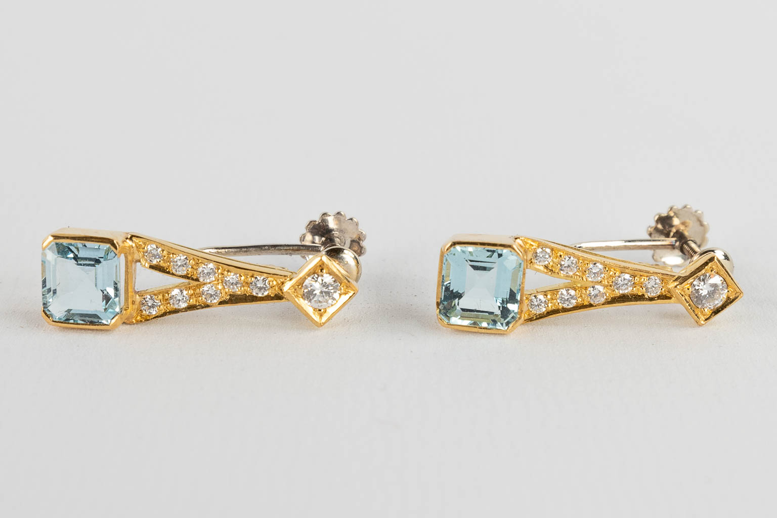 Een halsketting en twee oorbellen, 18 karaat geel goud, briljanten en Topaas/Aquamarijn, 26,77g.