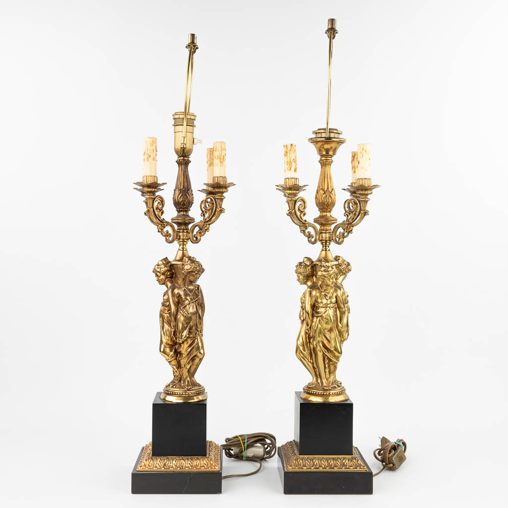 Een paar tafellampen in de vorm van de drie gratiën gemaakt uit verguld brons in Hollywood Regencystijl (H:90cm)