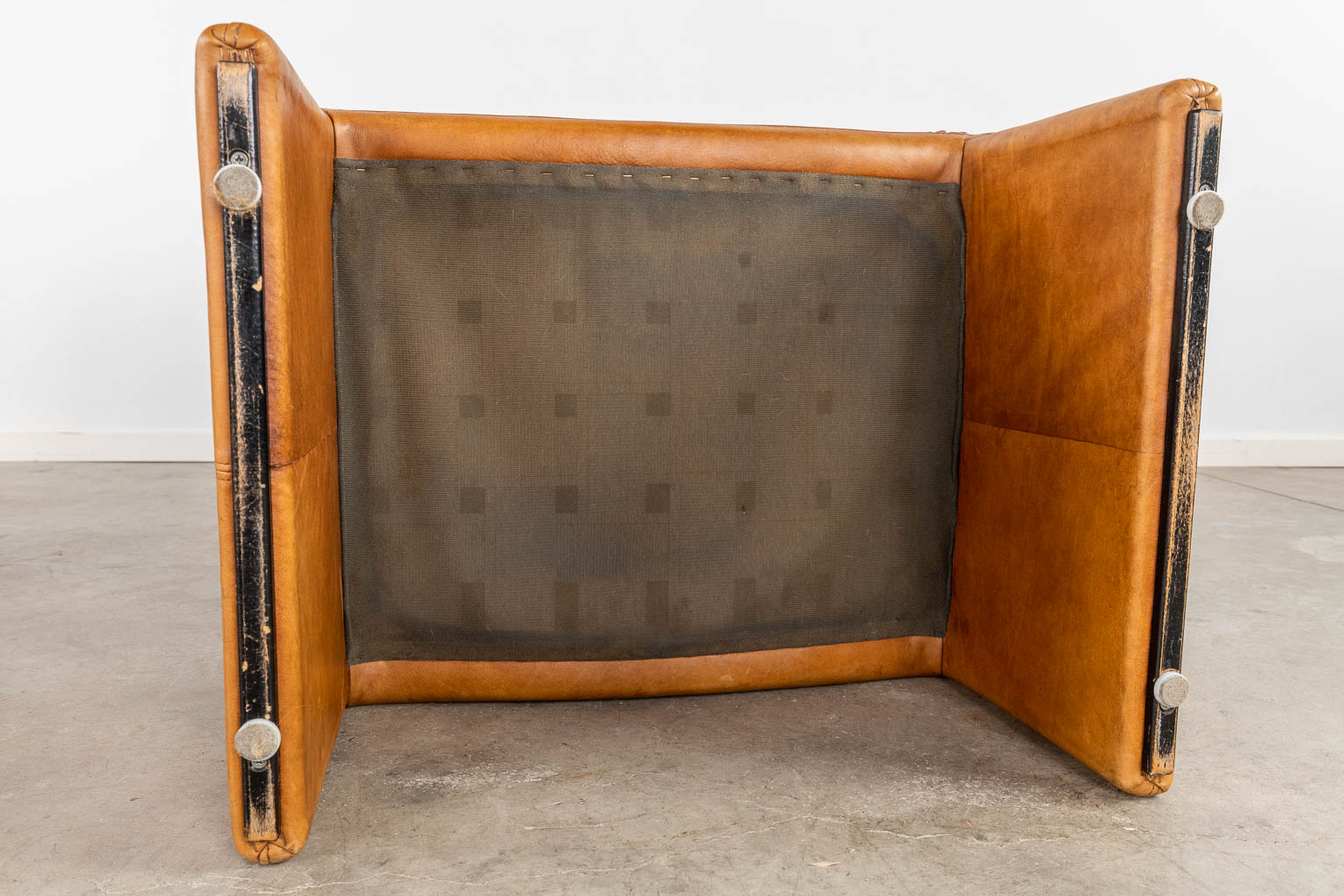 Een mid-century lounge zetel met bijhorende ottoman, leder. (D:86 x W:90 x H:96 cm)