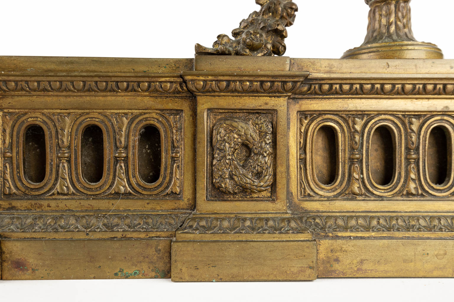 Een paar haardvuurbokken, brons in Lodewijk XVI stijl en afgewerkt met ramskoppen. (D:10 x W:37 x H:37 cm)