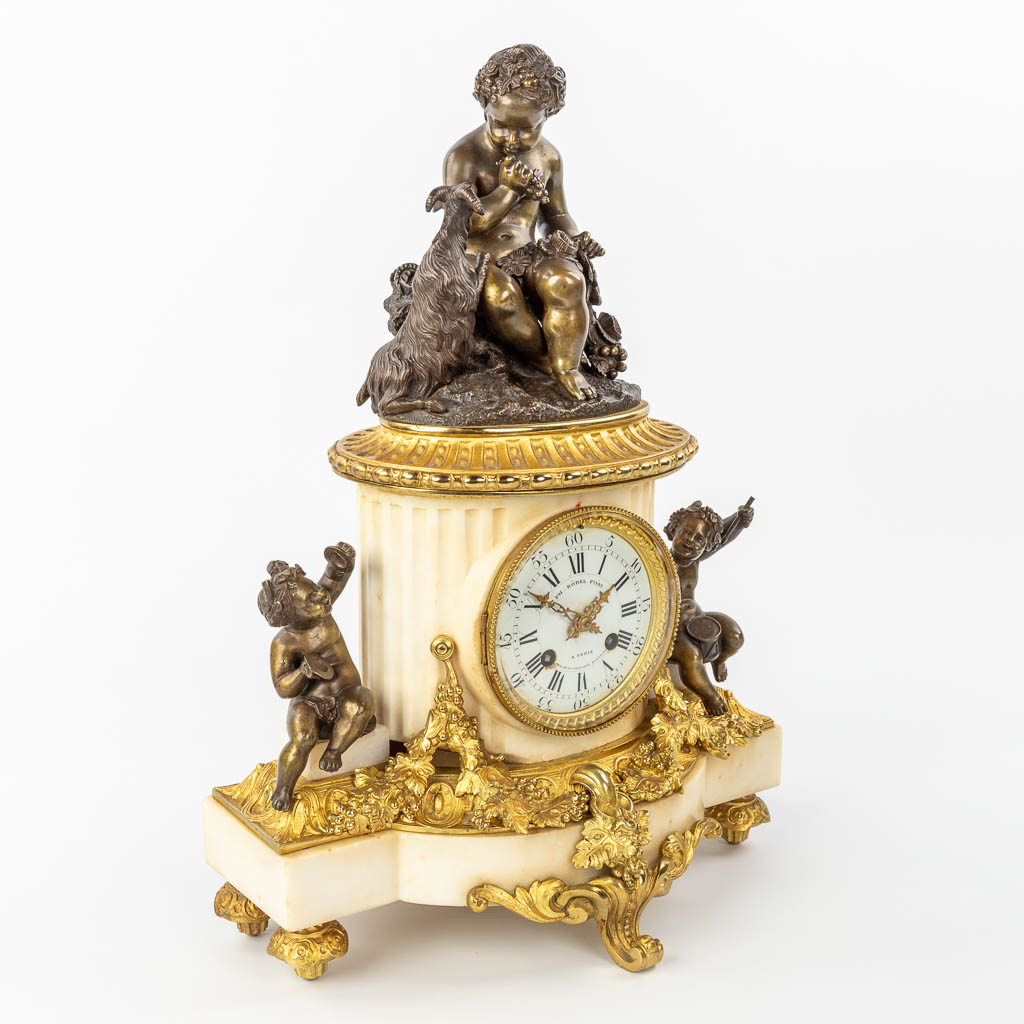 A clock made of marble and decorated with gilt and patinated bronze in Louis XVI style. (H:42cm)