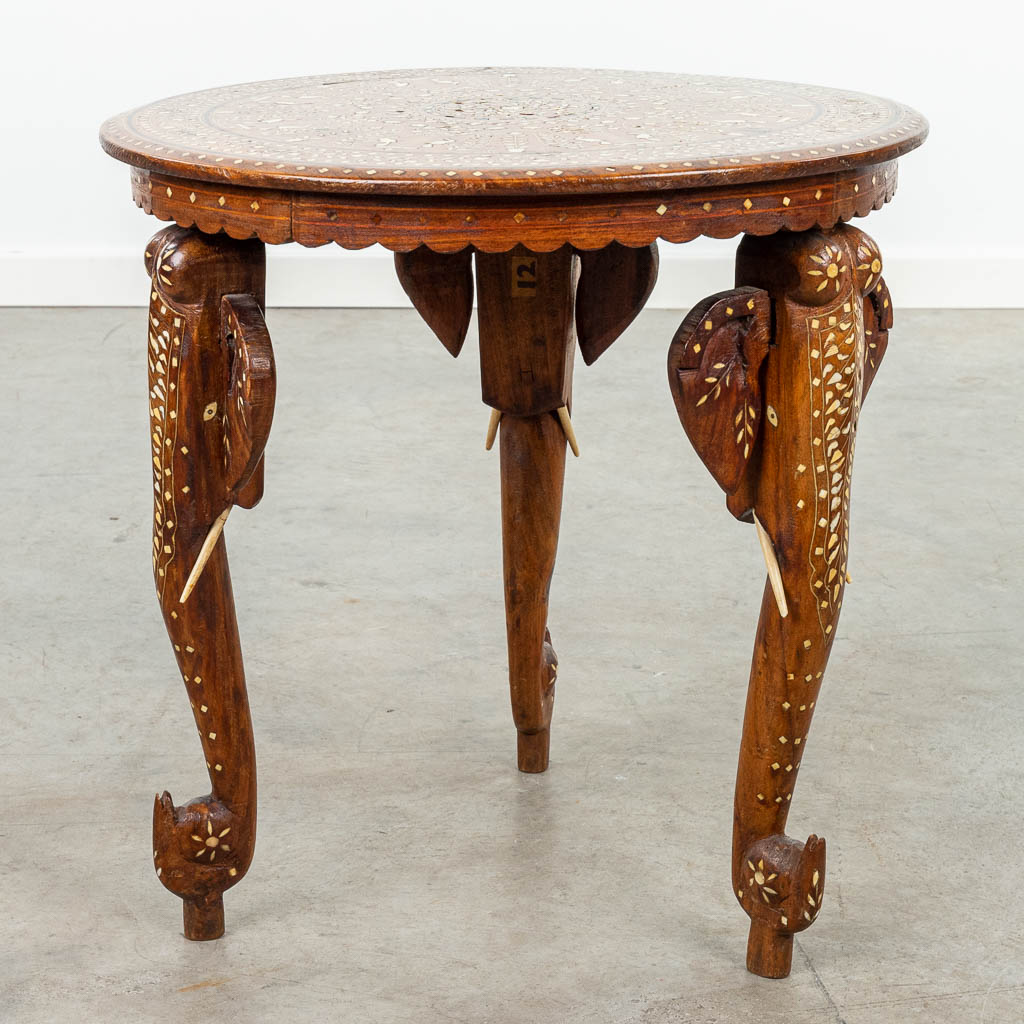 An Anglo-Indian coffee table made of hardwood and decorated with marquetry inlay and elephants. (H:47cm)