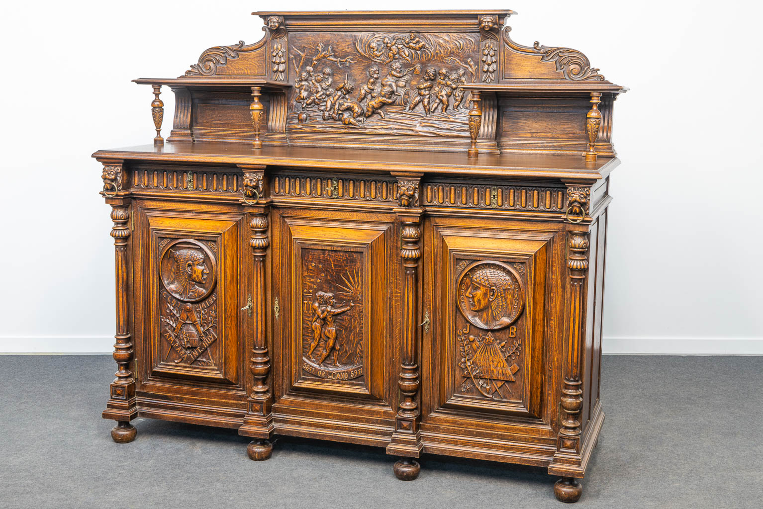 An exceptional sideboard with fine sculptured panels in symbols of the free masons, framaconnerie. Made in Eeklo. (H:172,5cm)