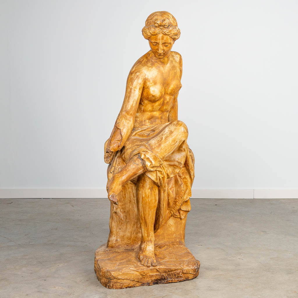 a large decorative statue of a seated lady, made of patinated plaster. 