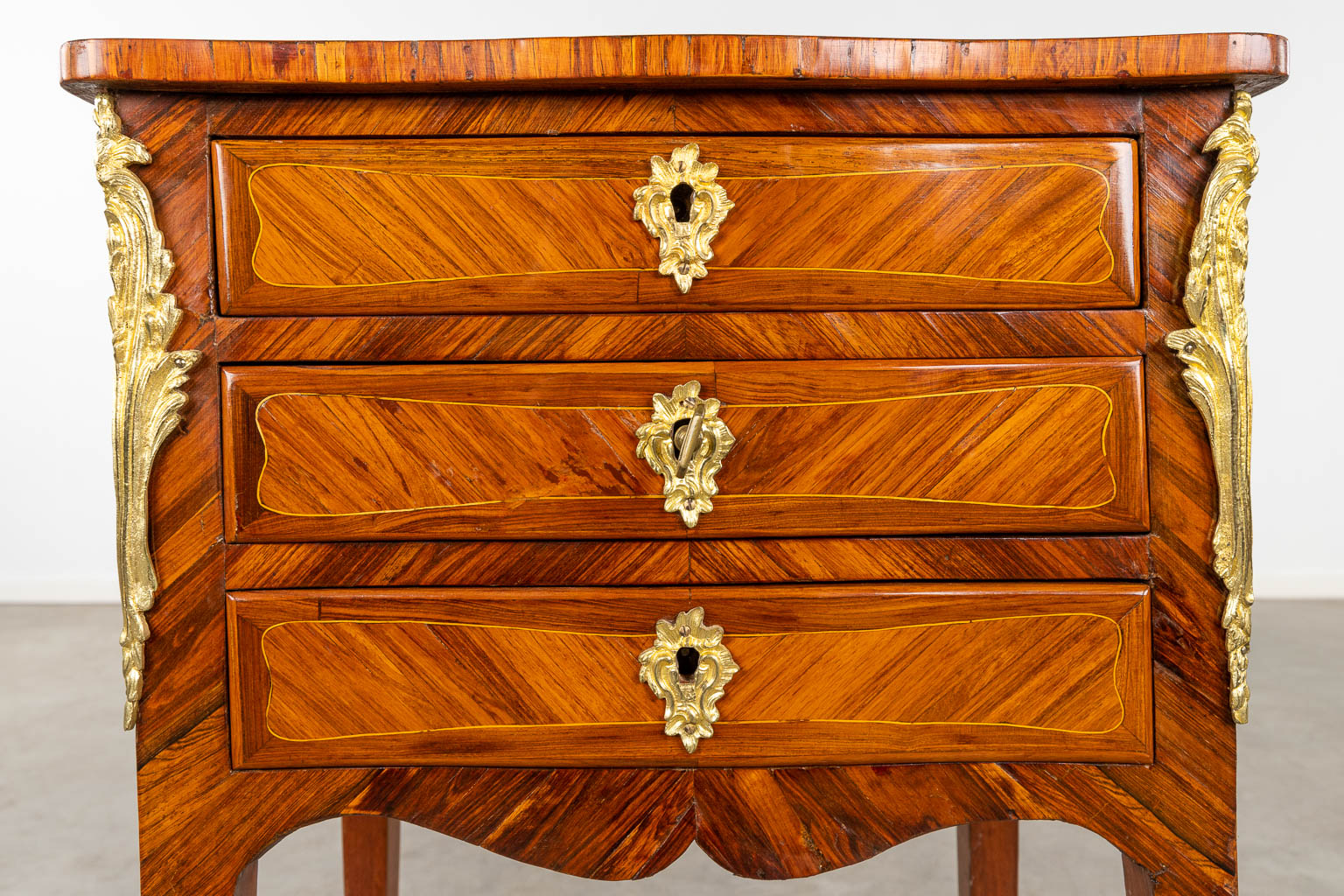 A small three-drawer cabinet, Louis XV, marquetry inlay mounted with bronze. 18th C. (D:32 x W:44 x H:70 cm)