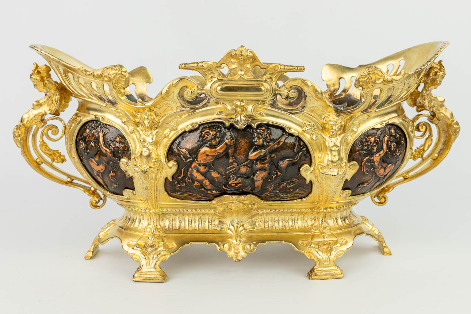 A three-piece mantle garniture made of jardinières, copper and gilt bronze decorated with putti. (H:22cm)