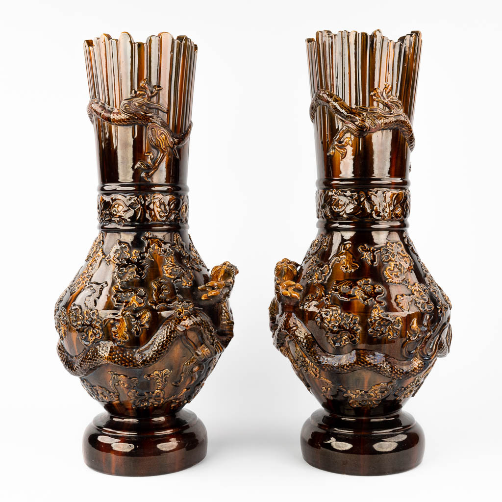 A pair of Chinese stoneware vases, decorated with relief dragons. 19th/20th century. (H: 62 x D: 26 cm)