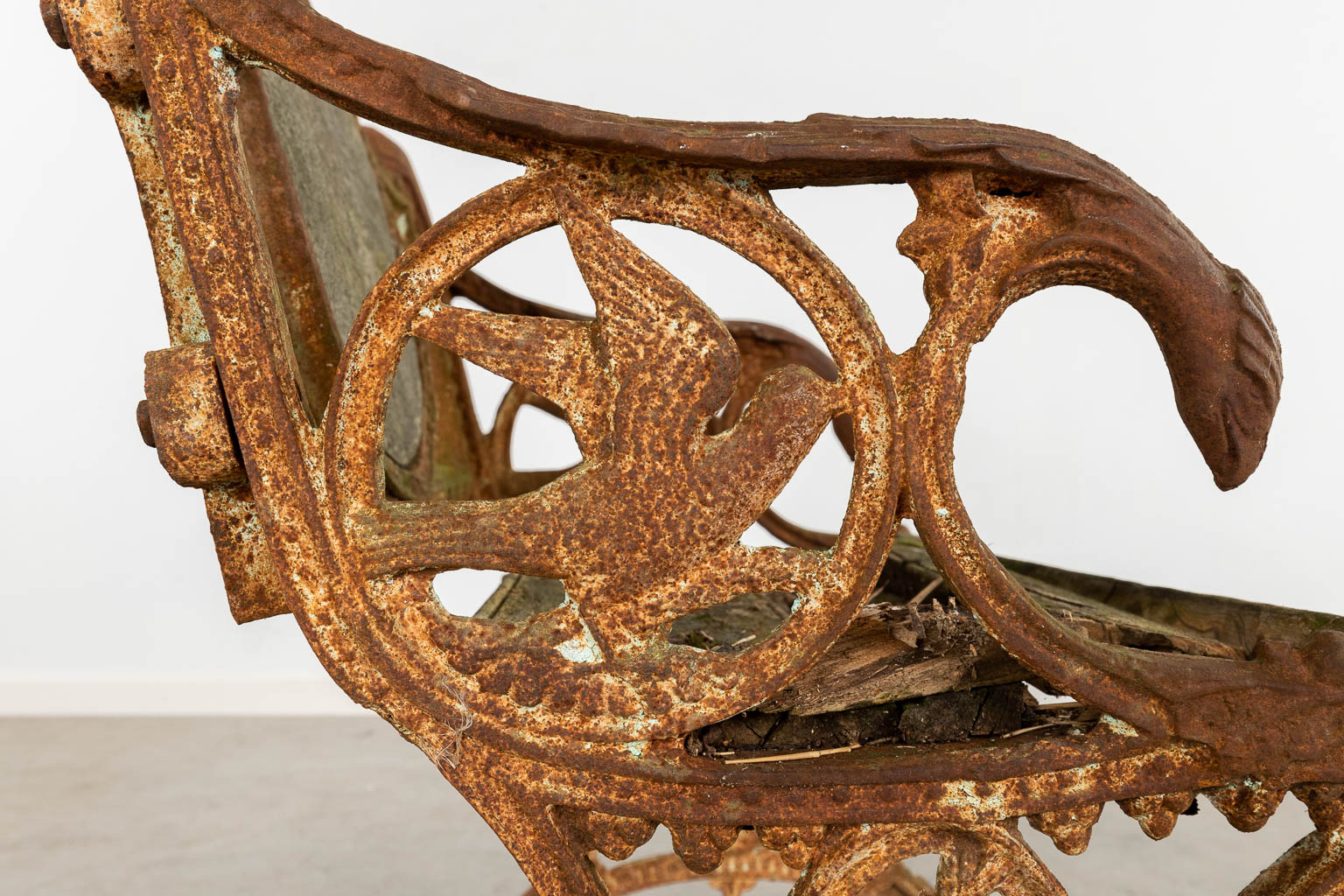 An antique garden bench, cast iron and decorated with birds and butterflies. (D:55 x W:72 x H:81 cm)