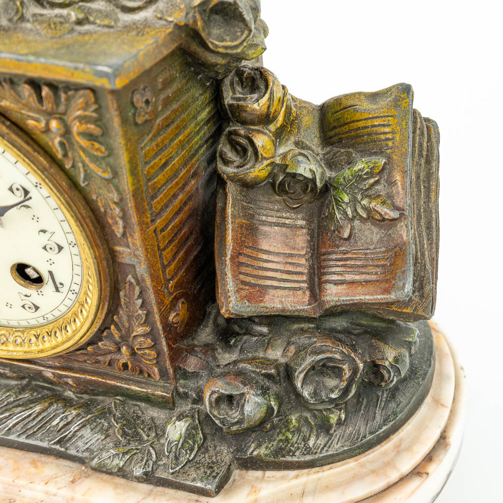 A three-piece mantle clock made of spelter and decorated with putti. (H:33cm)