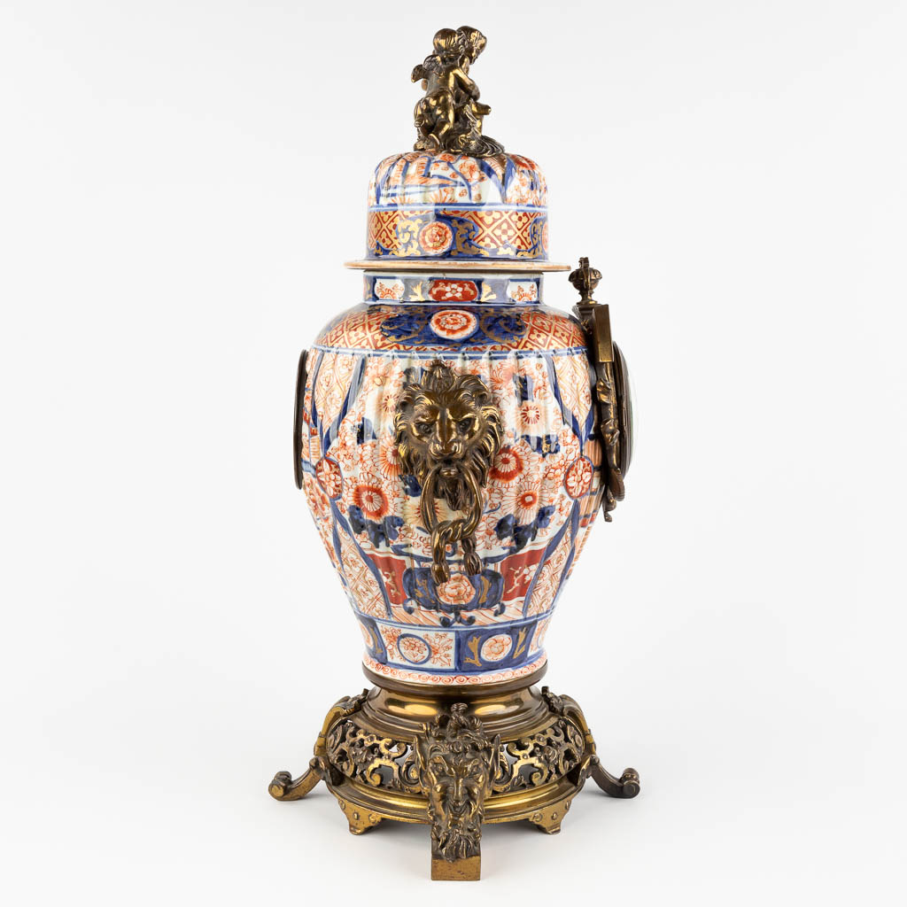 A mantle clock, Japanese Imari porcelain mounted with bronze and finished with lion