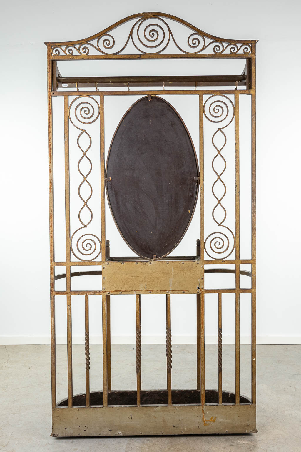A coathanger and umbrella stand with mirror made of wrought iron and marked Victor Rabier. (H:208cm)