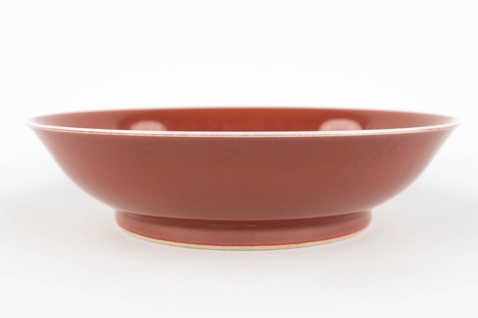 A Chinese bowl with monochrome red glaze, marked Qianlong. 19th/20th C. (H:5 x D:19 cm)