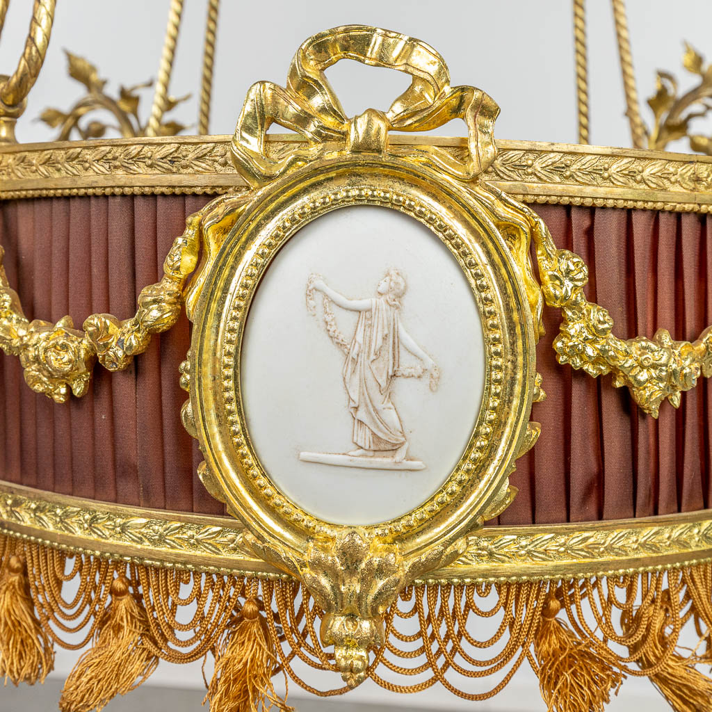 Een luchter gemaakt uit brons in Lodewijk XVI stijl en afgewerkt met biscuit plaquettes. (H:100cm)