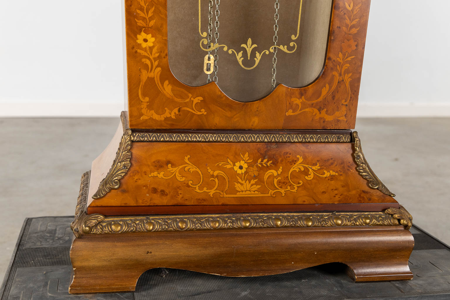 A cartel clock on a pedestal, Westminster movement, marquetry inlay and mounted with bronze. (L:29 x W:47 x H:190 cm)