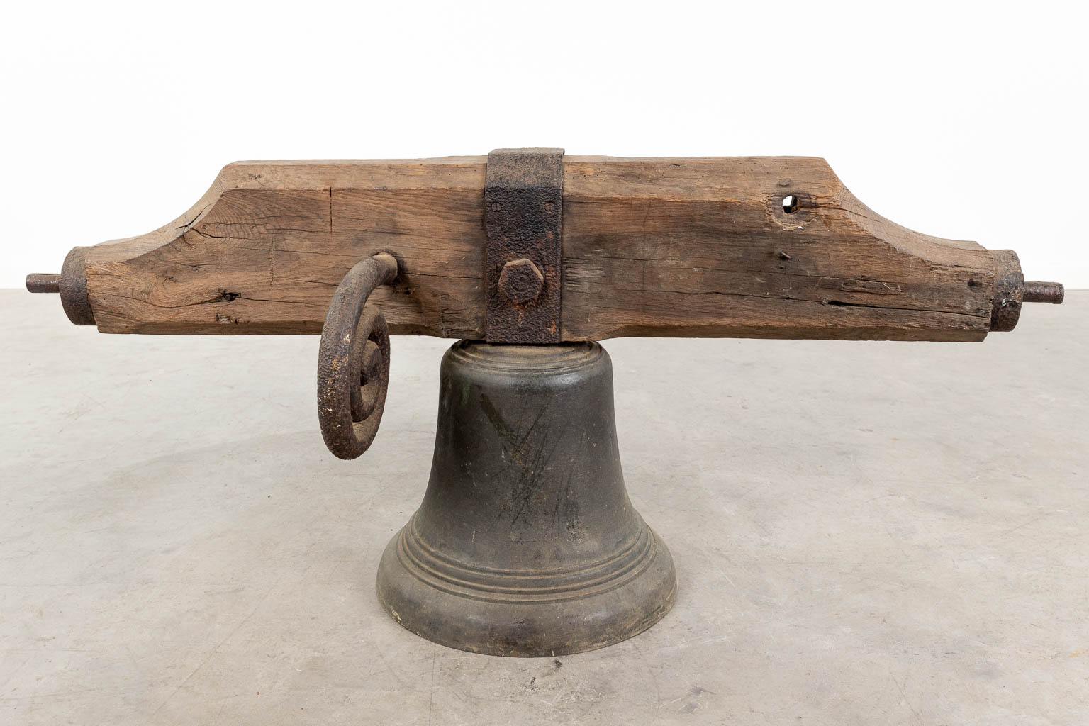 An antique bronze bell mounted on a wood base. 18th C. (W:120 x H:52 x D:36 cm)
