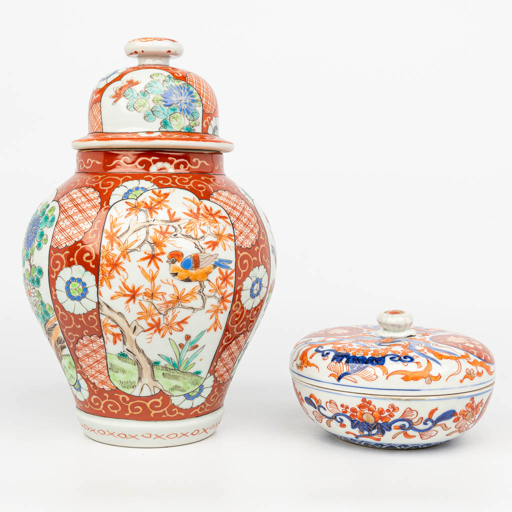 An assembled collection of Japanese porcelain, an Imari jar, and a Kutani vase with a lid. 