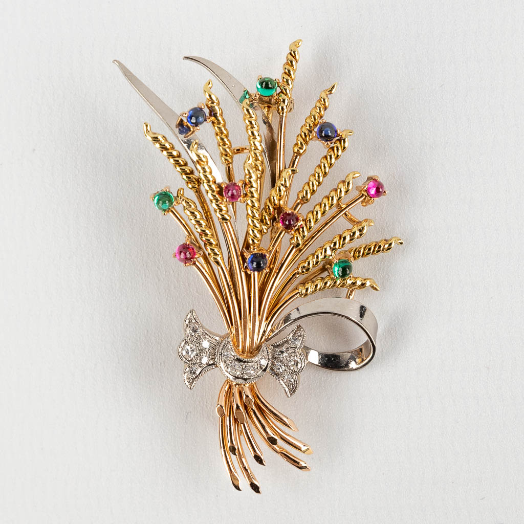 A brooch in the shape of a stack of wheat, with glass cabochons and facetted diamonds. 18kt gold, 13,27g. (W:3,7 x H:5,4 cm)