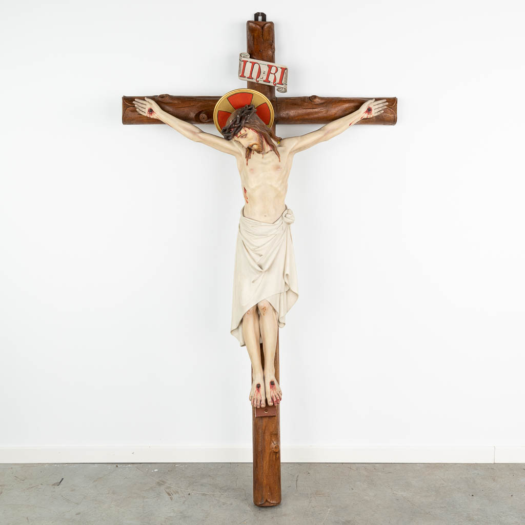 A large crucifix with 'Corpus Christi' made of patinated plaster, mounted on a cross made of sculptured wood. (H:174cm)