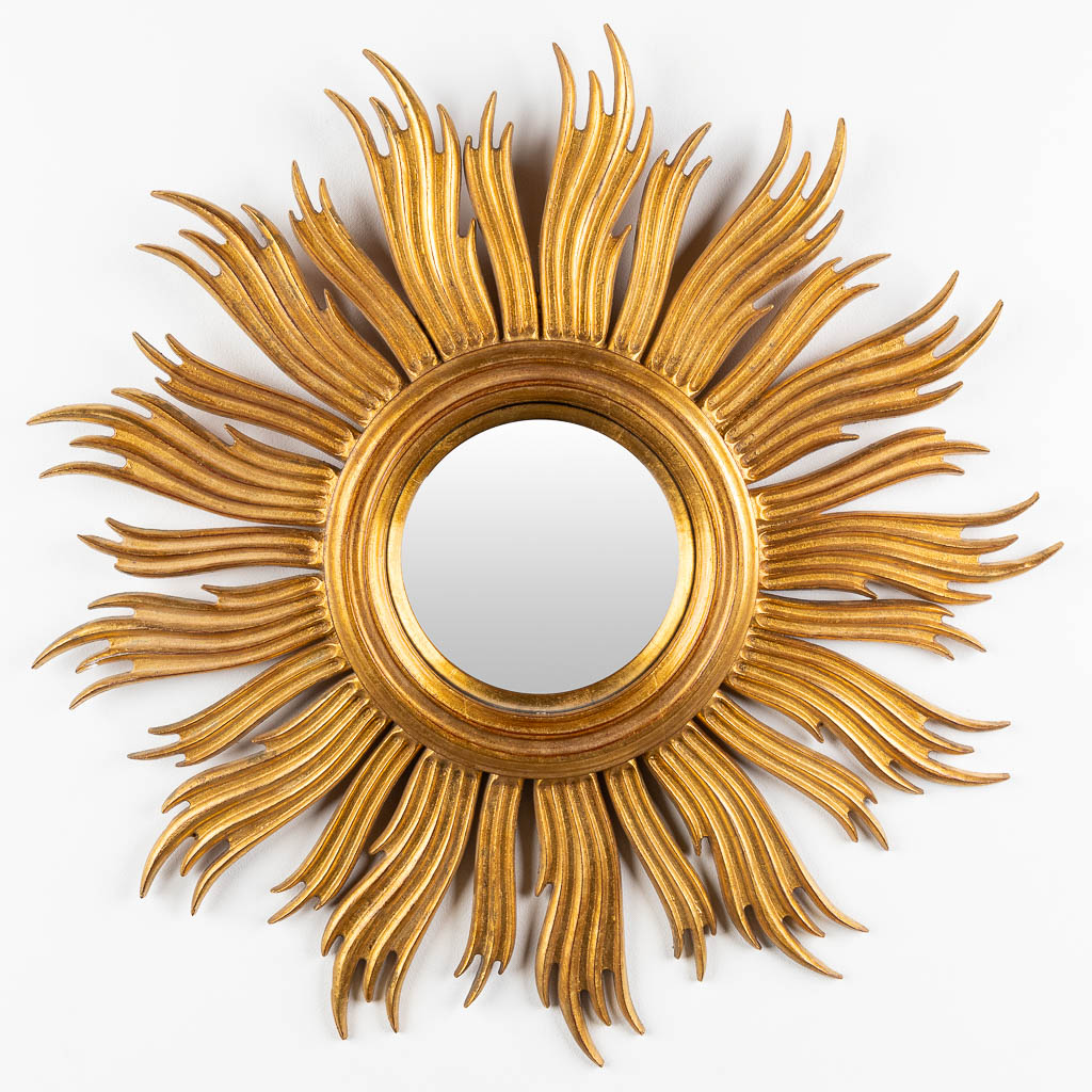 A sunburst mirror, sculptured wood with a convex mirror. Circa 1960. (D:63 cm)