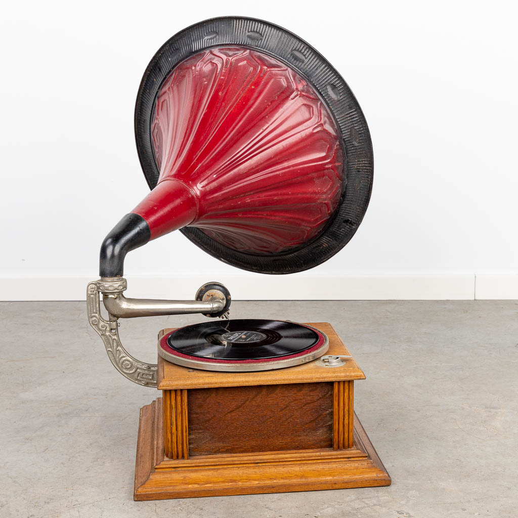 Een antieke grammofoon met grote hoorn en platen. (H:75cm)