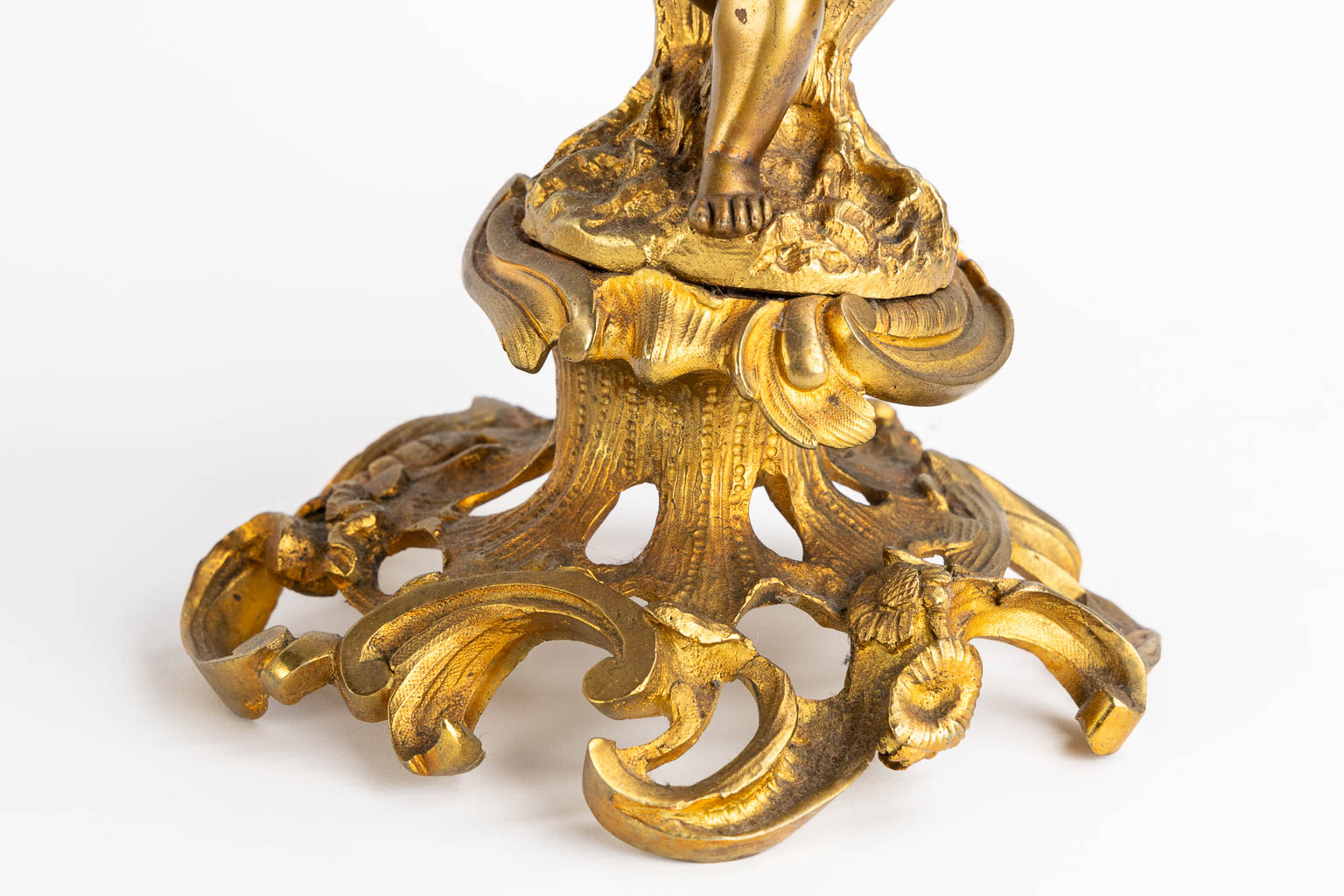 Een driedelige schouwgarnituur, klok met kandelaars, verguld brons. 19de eeuw. (L:21 x W:55 x H:48 cm)