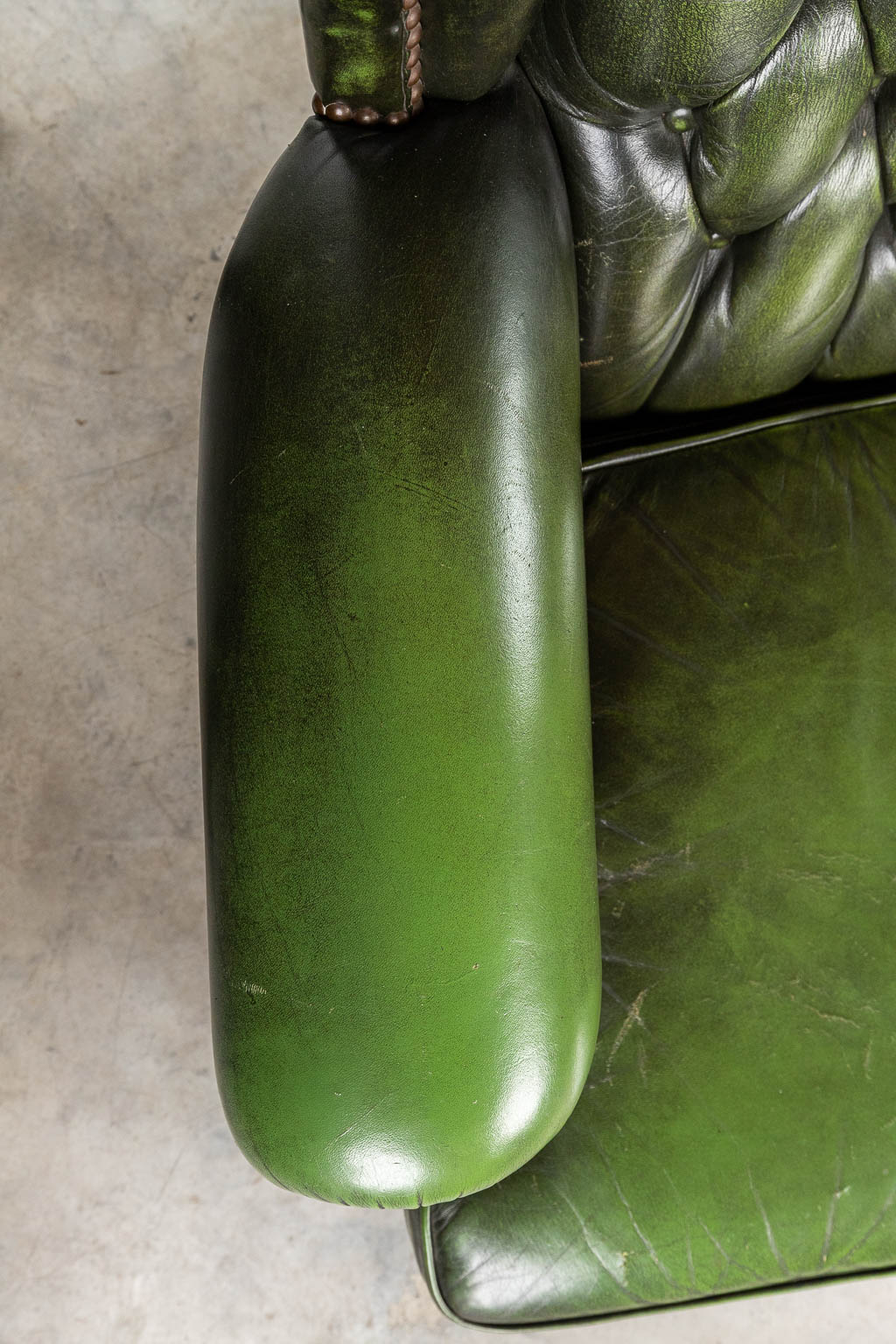 Een groen lederen armzetel met hoge rug in Chesterfield stijl. (H:107cm)