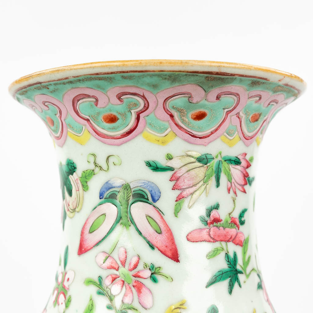 Een Famille Rose Chinese vaas met handgeschilderd decor versierd met bloemen, perziken en vlinders. 19de eeuw. (H: 43 x D: 22 cm