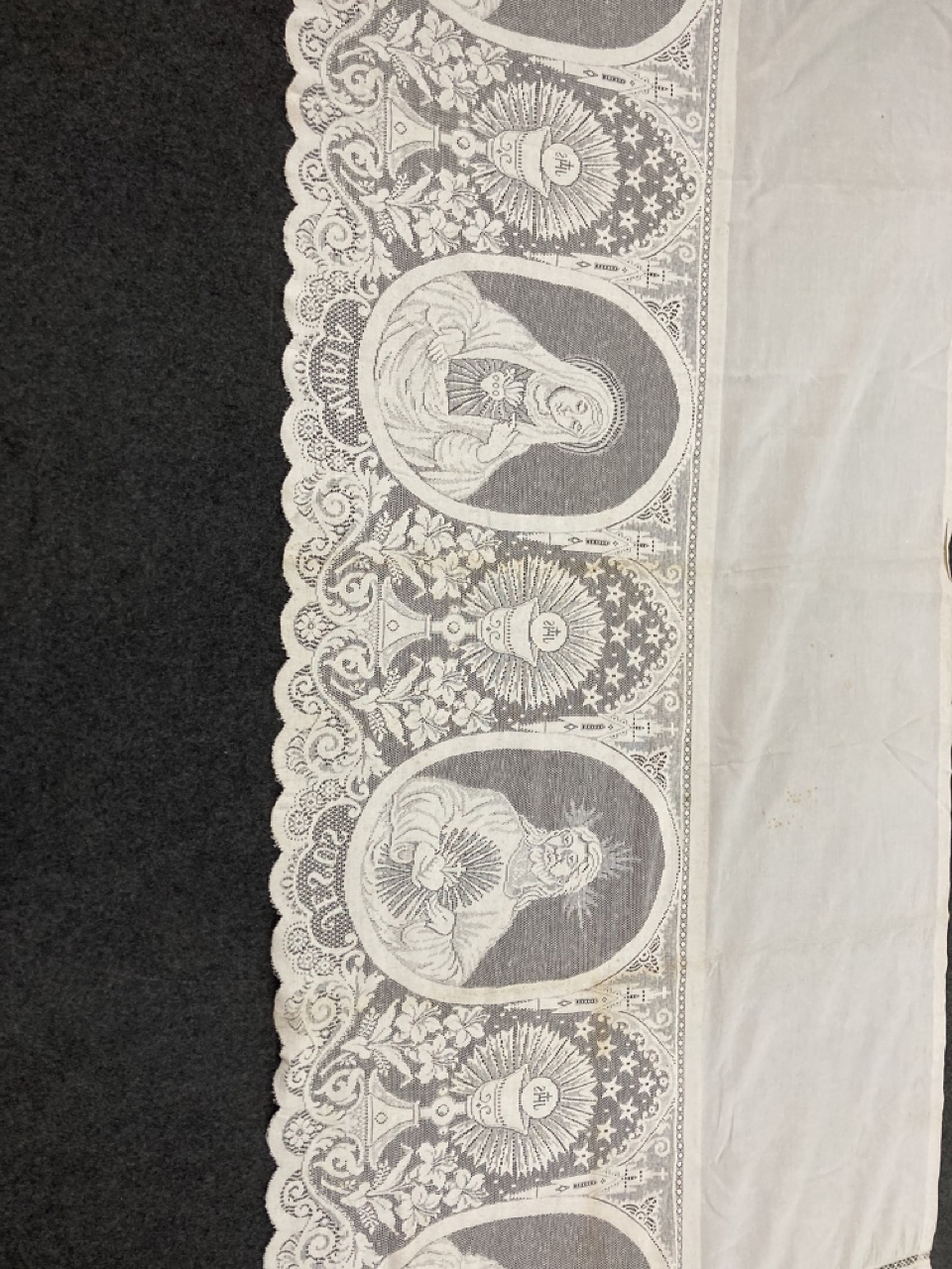 Een grote collectie textiel en kantwerk met religieuze motieven. (W:380 x H:90 cm)