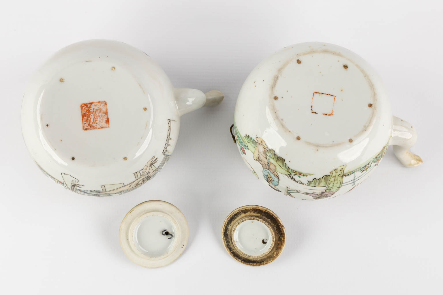 Two Chinese teapots, decorated with figurines. (L:13 x W:17,5 x H:10 cm)